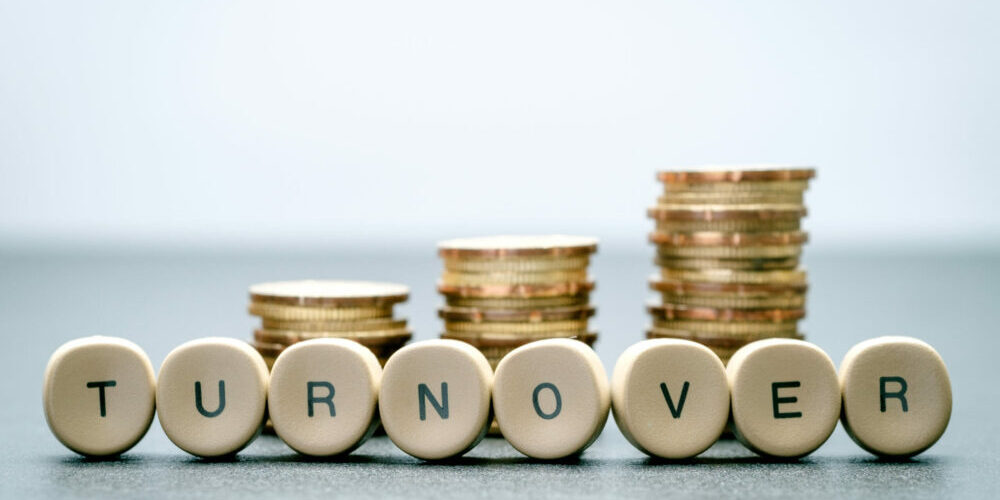 Coins stacked up in three columns and turnover spelled out in front