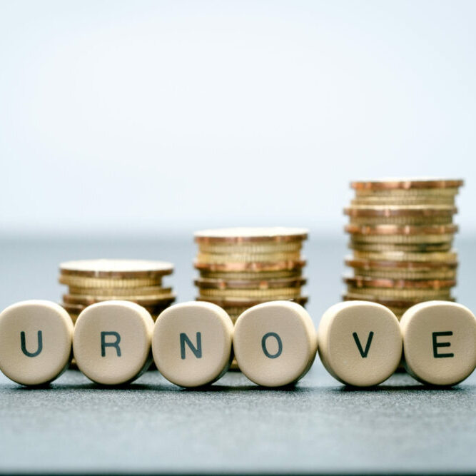 Coins stacked up in three columns and turnover spelled out in front