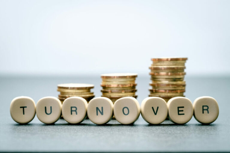 Coins stacked up in three columns and turnover spelled out in front