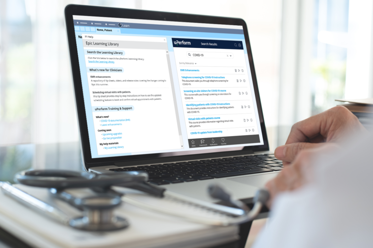 Physician working on laptop with uPerform's Epic in-app training content accessible via F1 Help on screen