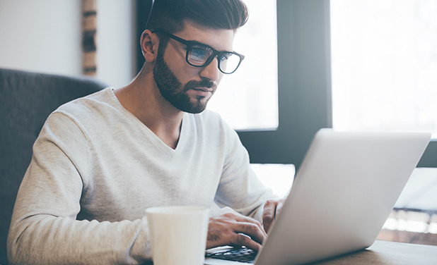 Man with glasses working on laptop