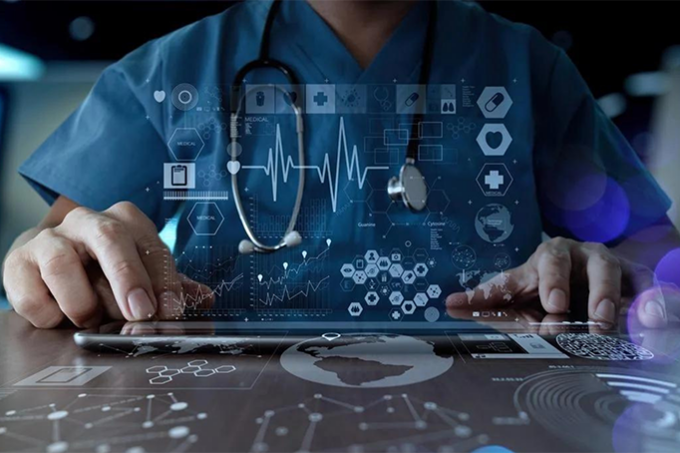 clinician wearing scrubs and stethoscope working on a high tech tablet