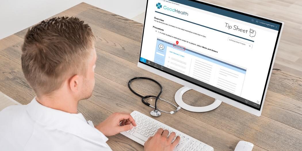 young male doctor accessing a tip sheet on a computer