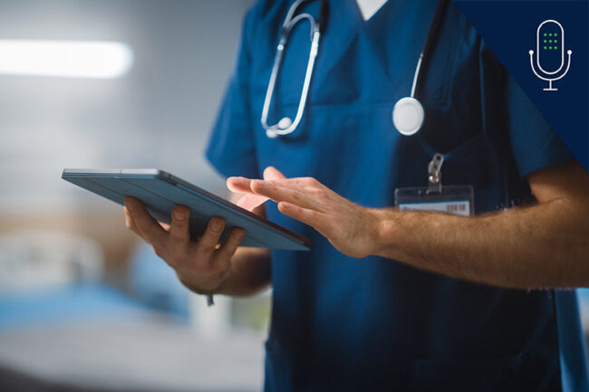 Close up of nurse, from shoulder to waist, using iPad while wearing scrubs and stethoscope