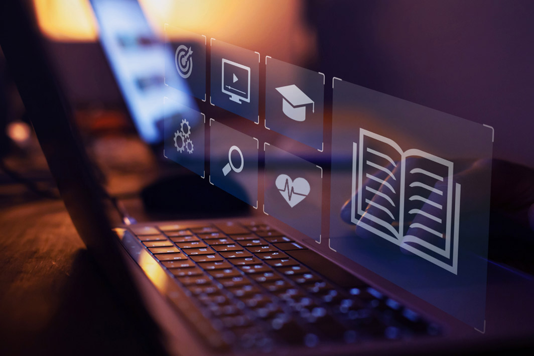 various digital icons - including a graudation cap, heart with a heart monitor line, search icon, and more - superimposed over laptop screen, representing virtual EHR training.