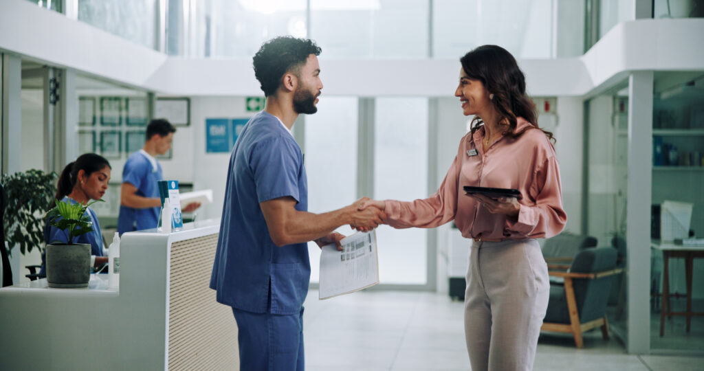 Doctor, meeting and tablet with handshake for hiring nurse at hospital. Medical colleagues shaking hands for recruitment together at hospital.