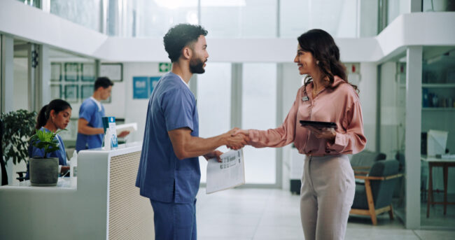 Doctor, meeting and tablet with handshake for hiring nurse at hospital. Medical colleagues shaking hands for recruitment together at hospital.