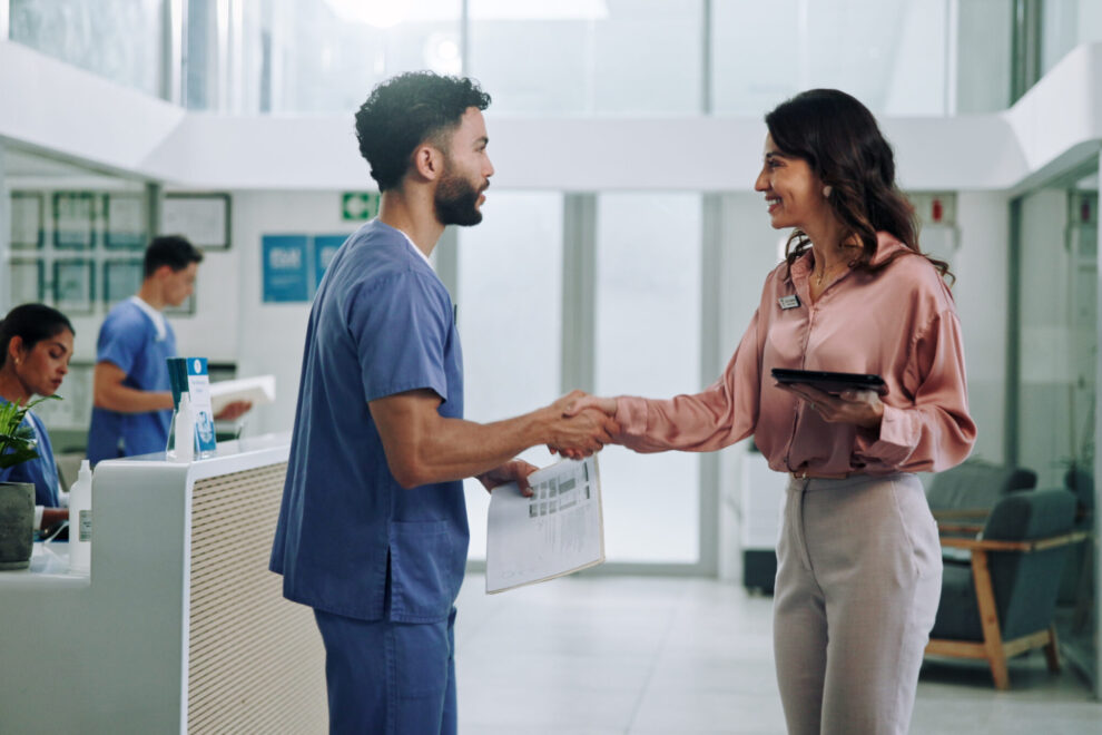 Doctor, meeting and tablet with handshake for hiring nurse at hospital. Medical colleagues shaking hands for recruitment together at hospital.